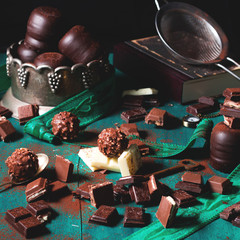 Dark and milk chocolate on green background - chocolate dark still life