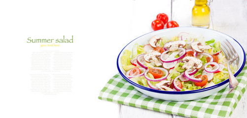 Healthy fresh summer salad with letucce, radish, cherry tomatoes, red onion and champignons with italian herbs on a wooden background with olive oil, closeup, copy space.