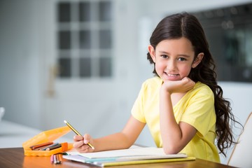 Portrait of smiling girl studying at desk 