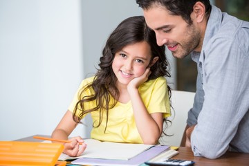 Obraz premium Portrait of smiling daughter with father at desk
