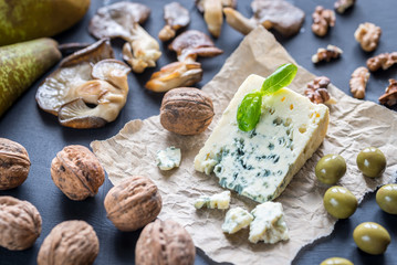 Fototapeta na wymiar Blue cheese with walnuts, oyster mushrooms and green olives