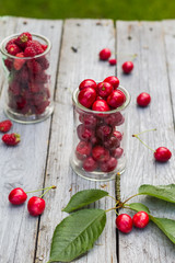 Glasses full freshly picked cherries raspberries