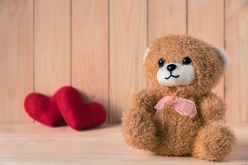 Obraz premium teddy bear with couple red heart background on wooden table