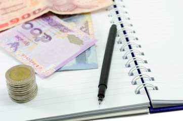  coin with money thailand and pen on notebook