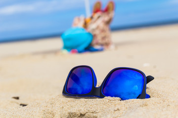 Fototapeta na wymiar Sunglasses gadgets sunbathers background