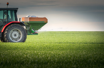 Obraz premium tractor fertilizing in field