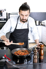 Chef preparing dishes in a frying pan