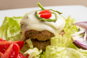 Double beef burger with melted cheese, asparagus and fresh vegetables