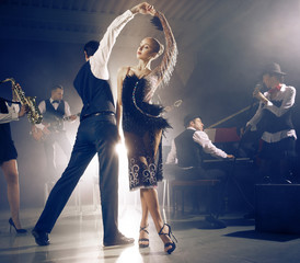 Dance couple dancing to a live band sounds - obrazy, fototapety, plakaty