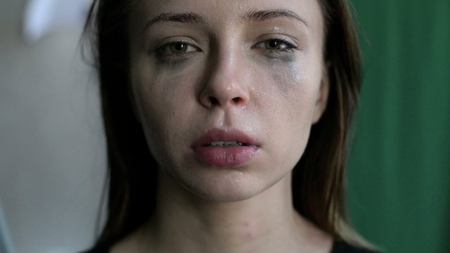 close up of a scared and crying woman with smeared make up