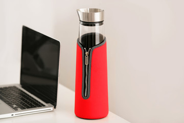 Thermoskanne aus Glas auf Schreibtisch