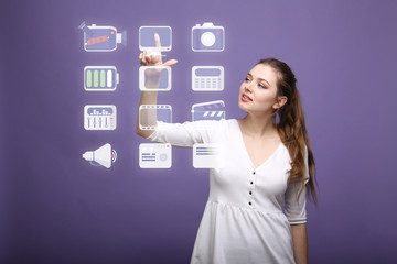 Woman pressing high tech type of modern multimedia buttons on a virtual background