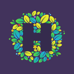 H letter logo in a circle of  leaves and flowers.