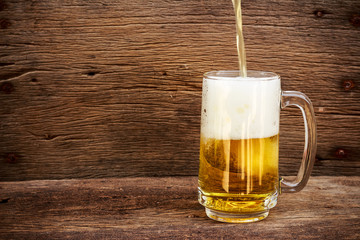 pouring beer in the glass on a wooden floor