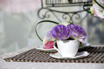 Brunch of blossom eustoma flowers in a white cup
