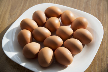 Fresh eggs in a white plate.