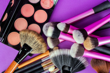 Makeup tools on purple background 