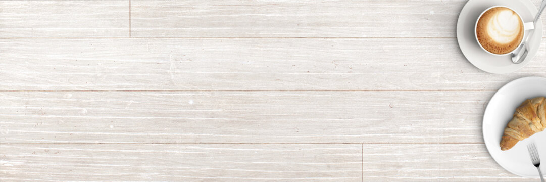 Tasse Cappucino mit Croissant serviert auf rustikalem Holztisch - Banner / Backround