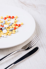 Plate with fork, knife and pills