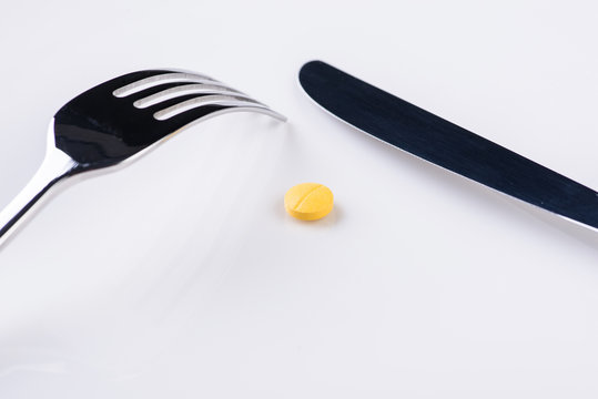 Plate with fork, knife and pill