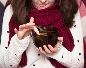 girl in a scarf drinking tea with lemon