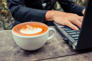 Handsome asian young man working on laptop at coffe shop