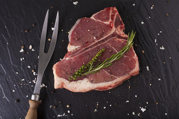 T-Bone fillet, red fresh raw fillet of T-Bone steak cut seasoning salt pepper and rosemary with...
