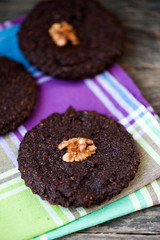 Round homemade brownies with walnuts on a rustic background