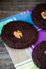 Round homemade brownies with walnuts on a rustic background