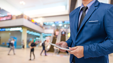 businessman using tablet with blurred event background