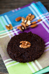 Round homemade brownies with walnuts on a rustic background