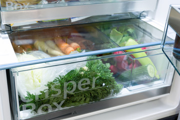 Open fridge filled with vegetables