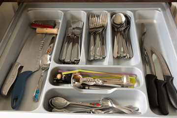 Opened drawer full of kitchenware