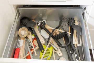 Opened drawer full of kitchenware