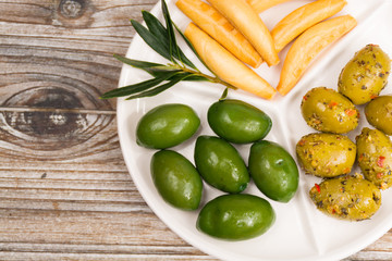 White board with giant  green olives and bread