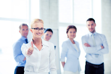 Obraz premium businesswoman in office showign thumbs up