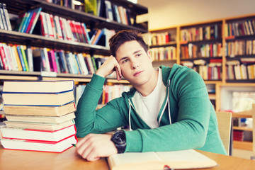 bored student or young man with books in library