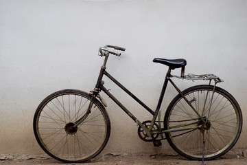 Naklejka na ściany i meble Old rusty vintage bicycle near the concrete wall at home