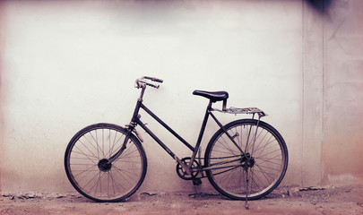 Naklejka na ściany i meble Old rusty vintage bicycle near the concrete wall at home