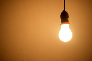 Incandescent light bulb orange light on wall 