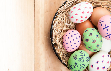 Easter eggs in nest on wooden background