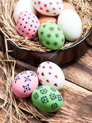 Easter eggs in nest on wooden background