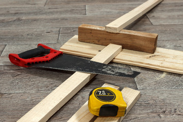 Home improvement, saw, timber and ruler on wooden floor