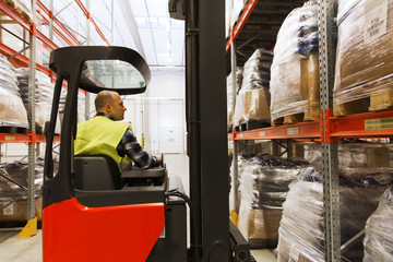 man on forklift loading cargo at warehouse © Syda Productions