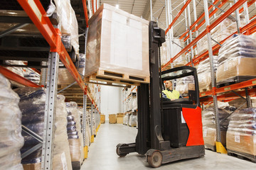 man on forklift loading cargo at warehouse © Syda Productions