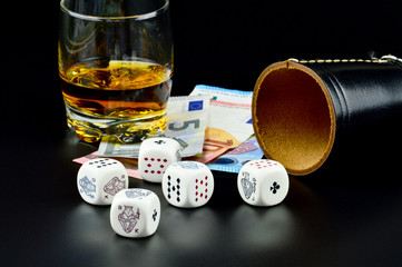 Pokerwürfel mit Würfelbecher, Geld und Alkohol
