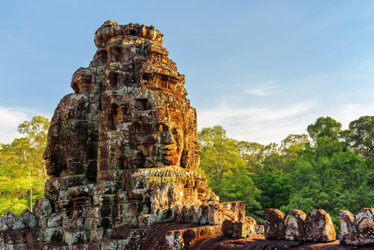 Enigmatic giant stone faces of Bayon temple in evening sun