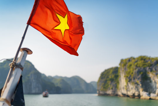 The flag of Vietnam fluttering on ship in the Ha Long Bay