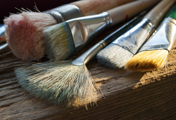 Verschiedene, gebrauchte Pinsel auf Holz / Treibholz Hintergrund