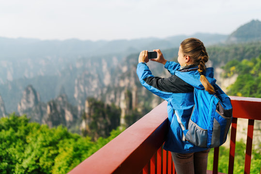 Female tourist taking photo of Zhangjiajie mountains, China
